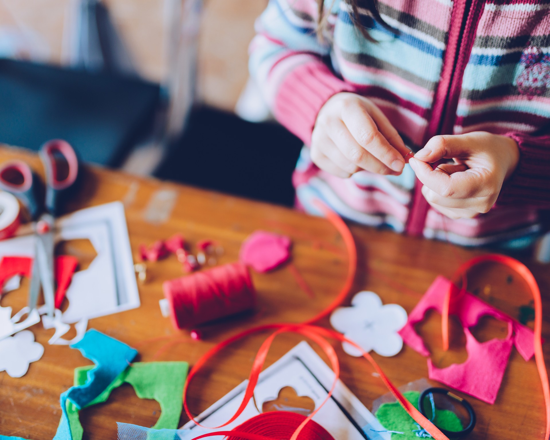 tailor art workshops for children - a girl sewing felt decorations